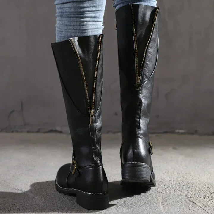 Knee-high buckle strap boots in black, side view